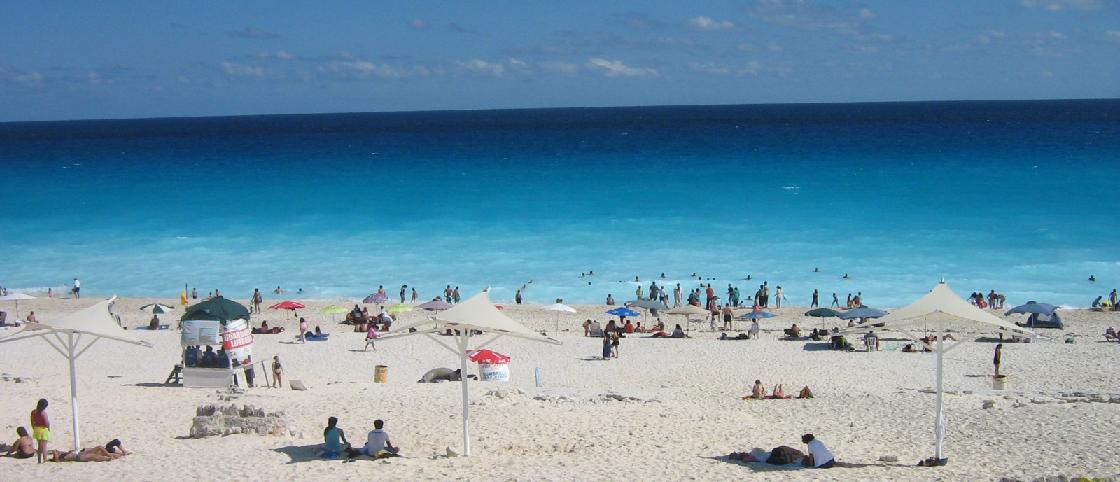 Playa Delfines, a public beach in Cancún with dramatic bluffs above the sand