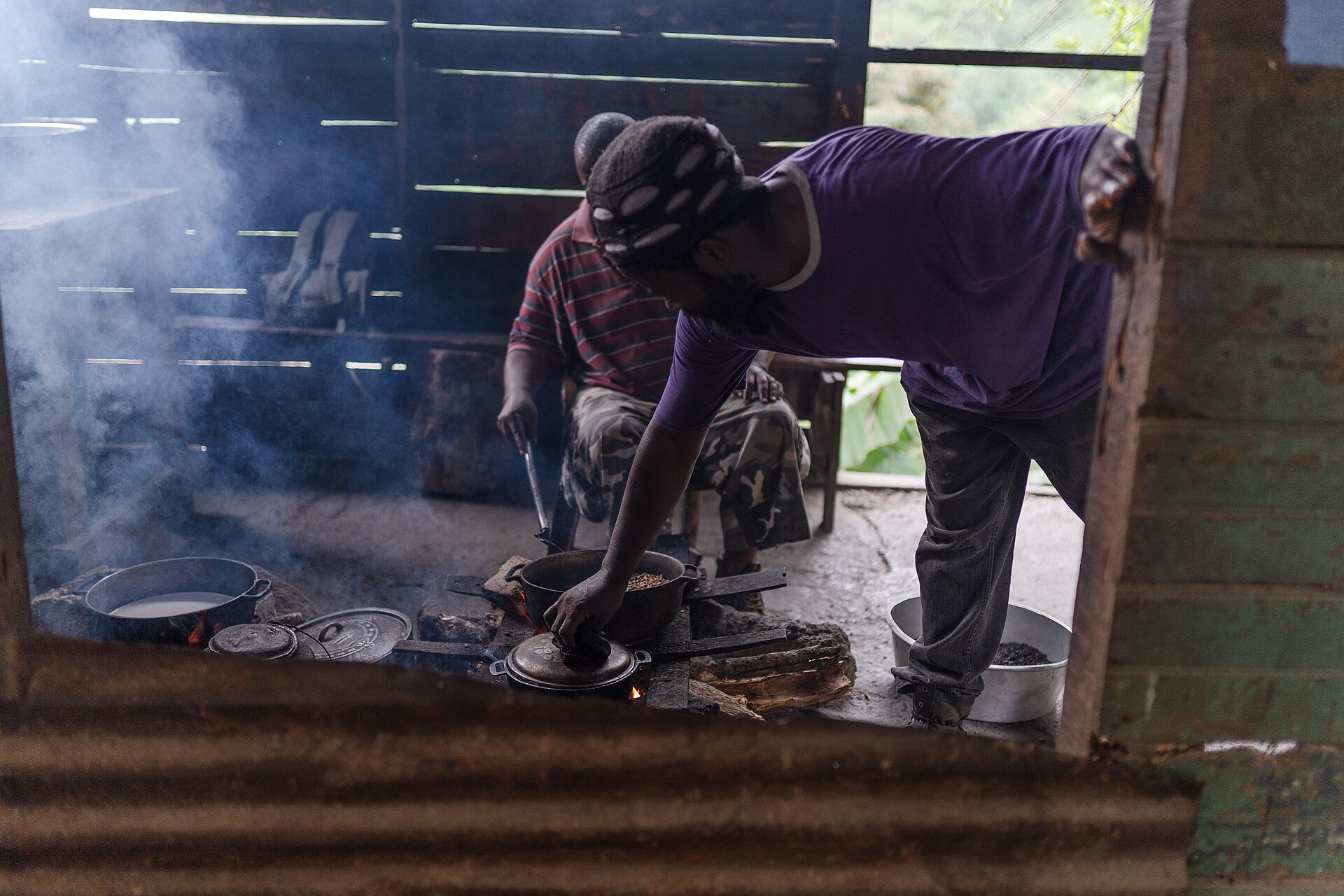 Blue Mountain coffee beans being roasted in a cast-iron skillet at a Jamaican estate