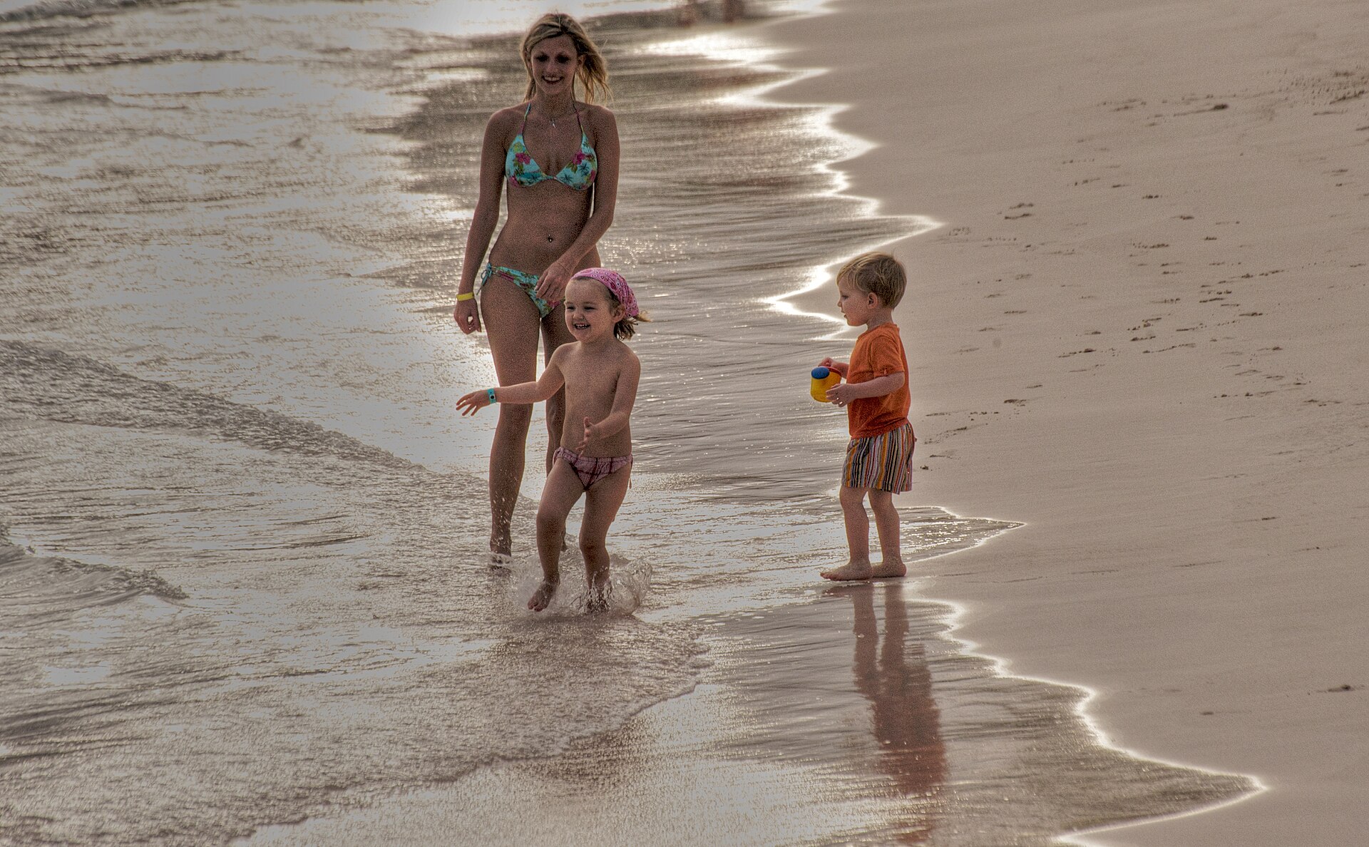 A mother and two children playing at a Punta Cana beach in the Dominican Republic